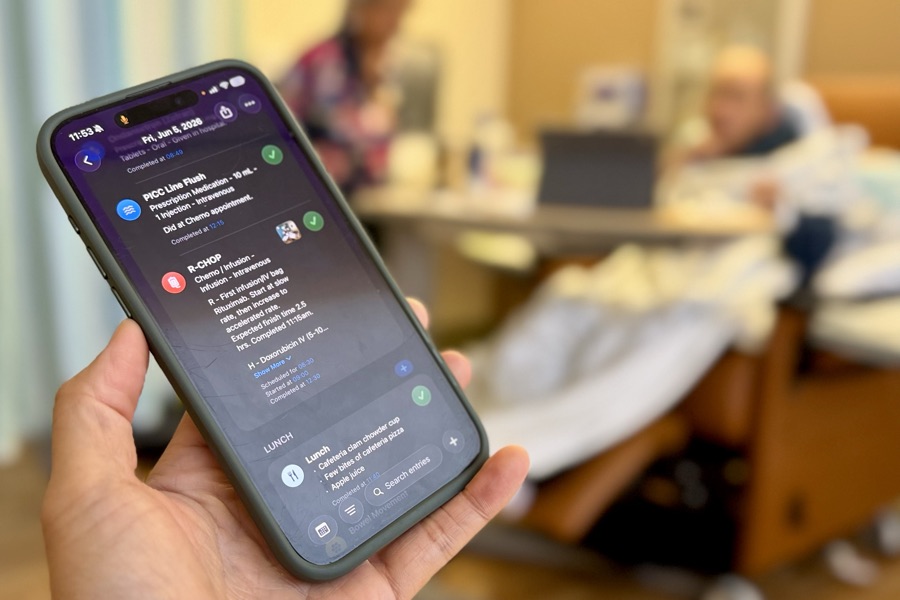 Hand holding an iPhone with C1B open during a caregiving day